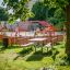 Moderner Spielplatz mit Bank & Tisch aus Lärchenholz und verzinktem Stahl, umgeben von Grünflächen.