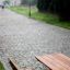Bank & Tisch aus Lärchenholz und verzinktem Stahl auf einem gepflasterten Weg in einem Park