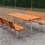 Holzbank und Tisch aus Lärcheholz mit verzinktem Stahlgestell auf gepflastertem Untergrund.