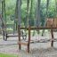 Holzspielplatz mit Dolomiti Wackelbrücke und Schaukeln im Park.