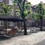 Quadratisch Bank & Tisch Set im gemütlichen Außenbereich eines Cafés mit Sonnenschirmen.