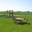 Holzbank und Tisch Quadratisch Bank & Tisch auf einer Wiese mit Klettergerüst im Hintergrund