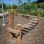 Holz-Spielgerät Sintra Wackelbrücke auf einem Spielplatz mit Rindenmulch-Boden.