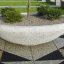 Halbkreisförmiger Blumentopf Fossano aus Beton mit kleinen Bäumen in einem modernen Garten.