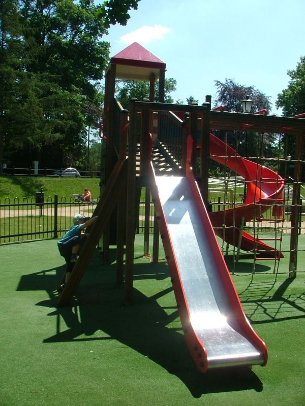 Lars Laj Kunstrasen 70 mit roter Rutsche, Klettergerüst und Türmchen im Park