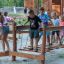 Kinder spielen auf dem Sahara Trimm-dich-Pfad aus Holz auf dem Spielplatz.