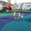 Kinderspielplatz mit Wetpour 80 Sicherheitsboden und Federspielgerät.