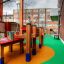 Kinderspielplatz mit Wetpour 80 Bodenbelag und hölzernen Spielgeräten.