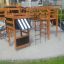 Holz-Spielgerüst Wetpour 80 mit Rutsche, Kletterwand und Schaukeln auf einem Spielplatz.