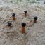 Holzpfosten im Sand, Spielgerät für Kinder, Madagascar (5 St.) auf einem Spielplatz.