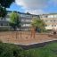 Kinder-Spielplatz mit Villa Spielhaus mit Sandkasten und Schaukeln in einem städtischen Park.