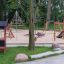 Spielhaus und Schaukeln im öffentlichen Park, ideal für Kinder.
