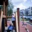 Kinder spielen auf einem Spielhaus mit Rutsche auf einem Spielplatz.