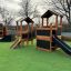 Spielplatz Schloss Spielhaus mit Rutsche und Kletterelementen im Freien.