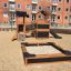 Bastei Spielhaus mit Kletternetz und Rutsche auf einem Sandplatz