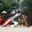 Berlin Spielanlage mit Spielturm und Rutschen auf Sandspielplatz im Park