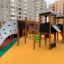 Berlin Spielanlage mit Spielturm, Rutschen und Kletterwand auf einem bunten Spielplatz.