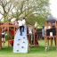 Kinder spielen auf Berlin Spielanlage mit Spielturm, Rutschen und Kletterwand im Freien.