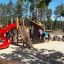 Kinder spielen auf einer Berlin Spielanlage mit Spielturm und Rutschen im Freien.