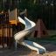 Kinder-Spielplatz mit Rutschen und Spielturm im Wald.