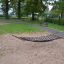 Hängematte Robinie im Park zwischen zwei Holzpfosten auf Sandboden.
