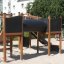 Aztec II Spielanlage mit Kletterwand, Tunnel und Rutsche auf einem Kinderspielplatz.