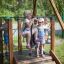 Kinder spielen auf der Seilbahn Mittel mit Plattform auf einem Spielplatz.