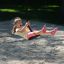 Seilbahn Mittel mit Plattform auf einem Sandspielplatz mit spielendem Kind