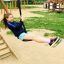 Mädchen lacht beim Schaukeln auf Spielplatz, Seilbahn Mittel mit Plattform.