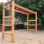 Horizontale Leiter auf einem Kinderspielplatz mit sandigem Untergrund.