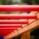 Rote horizontale Stangen der Spielplatzleiter aus Holz und Metall.