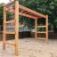 Horizontale Leiter auf einem Kinderspielplatz mit sandigem Untergrund.