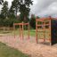 Kletterkiosk II Klettergerüst im Freien auf einem Spielplatz mit Kletterwand und Schaukel.