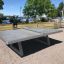 Freistehende Betontischtennisplatte in einem öffentlichen Park am Seeufer.