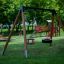 Doppelschaukel Rahmen mit Reifen und Standard-Schaukelsitzen auf einem Spielplatz.