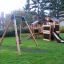 Schaukel Rahmen mit Rutsche und Spielhaus im Garten.