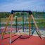 Breite Einzelschaukel Rahmen mit runder Sitzfläche auf einem Spielplatz