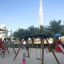 Kinder spielen auf Schaukel Rahmen (Einzeln, breit) im städtischen Spielplatz.
