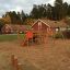 Panther Kletteranlage auf einem Spielplatz mit Holzstrukturen und roten Rutschen.