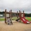 Holzspielplatz Der Knirps Turm mit Rutsche mit Rutsche und Kletterwand auf Sandboden.