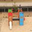 Buntes Schloss Camelot Spieltürme mit Rutsche auf einem Sandspielplatz.