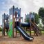 Schloss Camelot Spieltürme mit Rutsche auf einem Spielplatz mit Grünfläche.