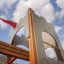 Kleine Schloßbrücke Spielturm mit Rutsche, Kinderkletterturm im Schlossdesign mit roter Fahne.
