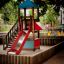 Kinder-Spielturm mit Rutsche und Klettergerüst in einem Spielplatz.