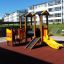 Moderner Smart Spielanlage mit Rutsche, Kletterwand und Brücke auf einem Spielplatz.