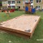 Holz-Sandkasten im Garten eines Kinderspielplatzes.
