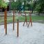 Trainingsrack aus Holz auf einem Spielplatz mit Sandboden und Bäumen im Hintergrund.
