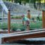 Training Twist & Sit Spielplatzgerät aus Holz und Metall zur motorischen Förderung von Kindern.