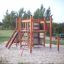Kramladen Klettergerüst mit Rutsche auf einem Spielplatz mit Sandboden.