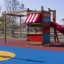 Kleiner Dschungel Klettergerüst mit Rutsche und bunte Spielplatzgeräte für Kinder.